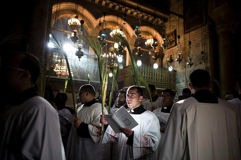 Katholische Mönche mit Palmzweigen während der Palmsonntagsprozession in der Grabeskirche in Jerusalem.