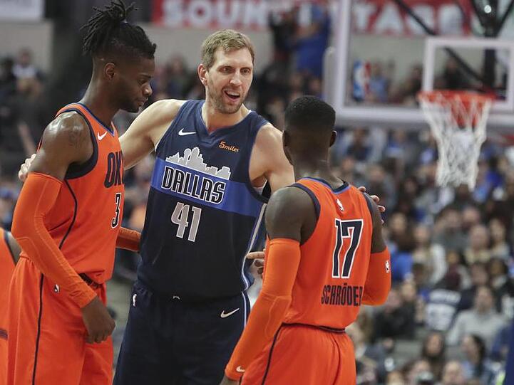 Mavericks-Star Dirk Nowitzki (M.) begrüßt Dennis Schröder (r) auf dem Parkett.