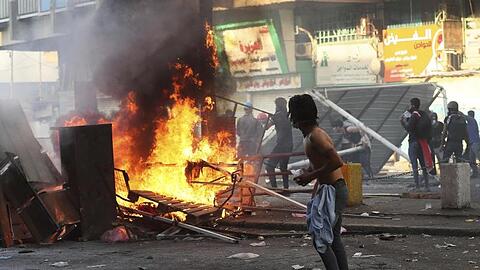 Regierungsfeindliche Demonstranten haben in Bagdad Barrikaden in Brand gesteckt und Straßen blockiert.