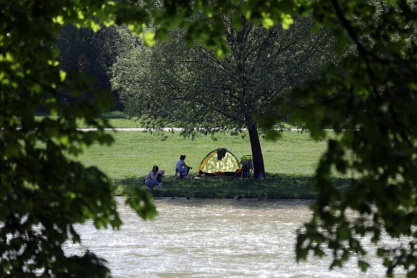 Naherholung pur: der Blick über die Isar, wo ein kleines Zelt aufgeschlagen ist.
