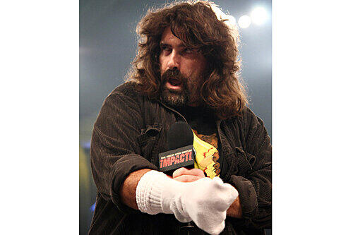 Beim Wrestling ist alles erlaubt: Mit einer Socke attackiert Mick Foley den Ringrichter.