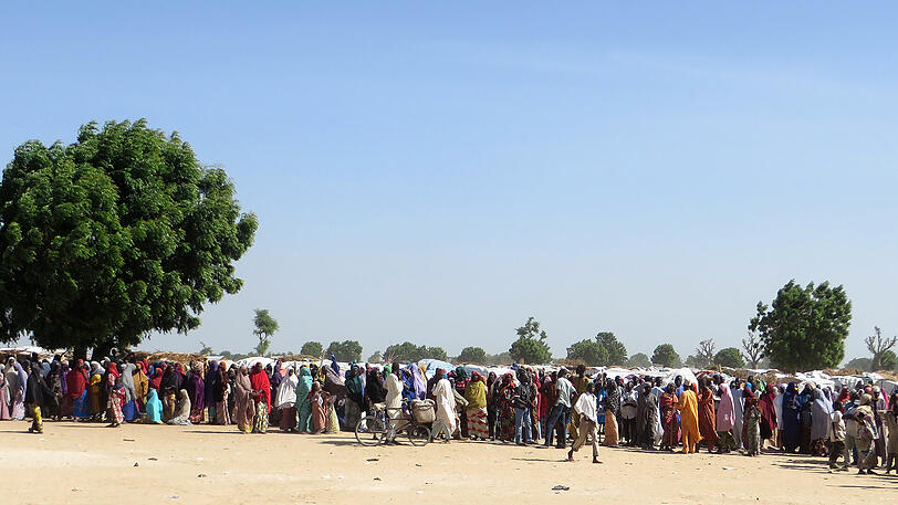 In langen Schlangen stehen Menschen im Lager Muna Garage an, um Nahrungsmittel zu bekommen. Sie gehören zu den Menschen, die vor dem Terror der Boko Haram geflohen sind.