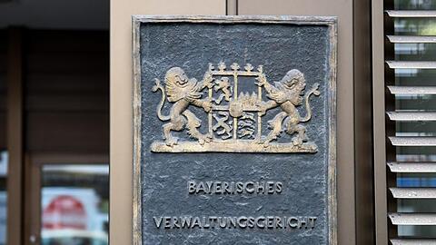 Ein Schild hängt am Eingang am Verwaltungsgericht München. Foto: Tobias Hase/Archivbild