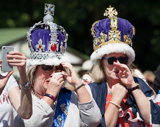 Zwei Frauen mit Kronen weinen während der Übertragung der Hochzeits-Zeremonie vor Schloss Windsor.