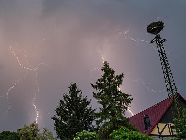 Mehrere Blitze eines Gewitters erhellen den Abendhimmel über Sieversdorf in Brandenburg.