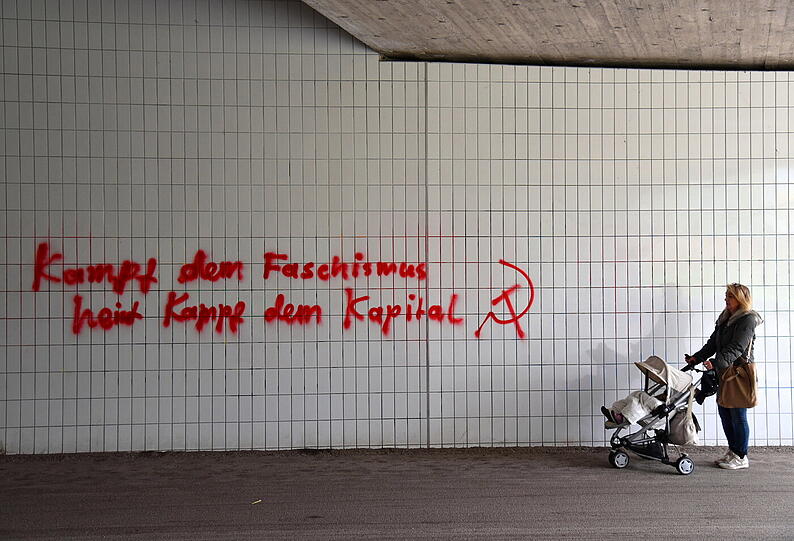 Und nebenan sinniert eine junge Mutter über den Graffitischriftzug auf den Fliesen: &bdquo;Kampf dem Faschismus, ... Kampf dem Kapital&ldquo;.