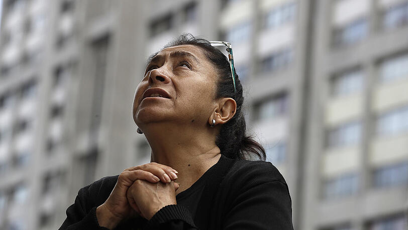 Eine Frau betet bei einer Messe für die Opfer des Erdbebens unter freiem Himmel in Mexiko-Stadt. Eine Frau betet bei einer Messe für die Opfer des Erdbebens unter freiem Himmel in Mexiko-Stadt.
