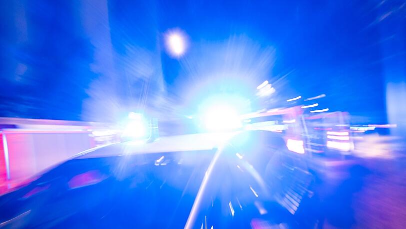 Ein Streifenwagen der Polizei steht mit Blaulicht an einem Einsatzort.