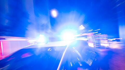 Ein Streifenwagen der Polizei steht mit Blaulicht an einem Einsatzort.