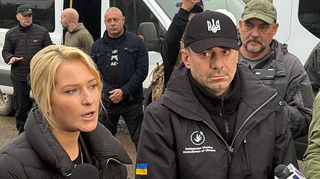 Die Menschenrechtsbeauftragten von Russland, Jana Lantratowa (l), und der Ukraine, Dmytro Lubinez (M, schwarze Kappe), k&ouml;nnen sich auch k&uuml;nftig weitere gemeinsame Hilfsaktionen vorstellen.