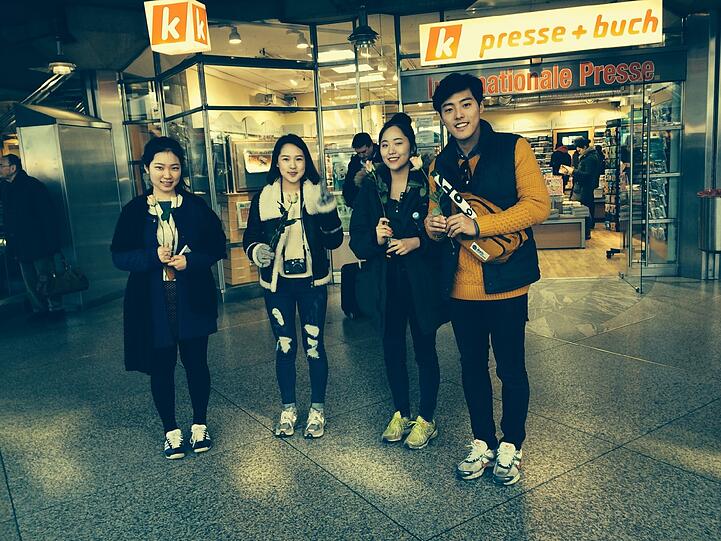 ... genauso wie diese koreanische Touristengruppe, die in der Bahnhofshalle die geschenkten Rosen hoch hält.