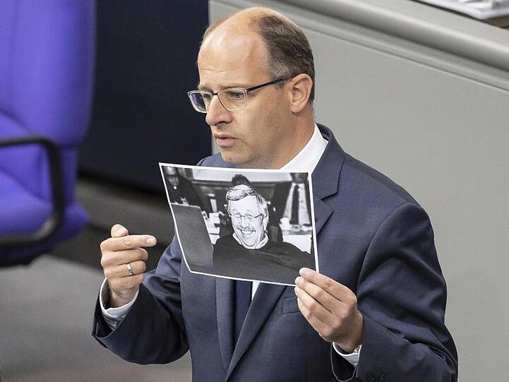 Michael Brand (CDU) hält bei seiner Rede im Bundestag ein Bild des ermordeten Kasseler Regierungspräsidenten Walter Lübcke.