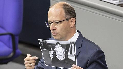 Michael Brand (CDU) hält bei seiner Rede im Bundestag ein Bild des ermordeten Kasseler Regierungspräsidenten Walter Lübcke.