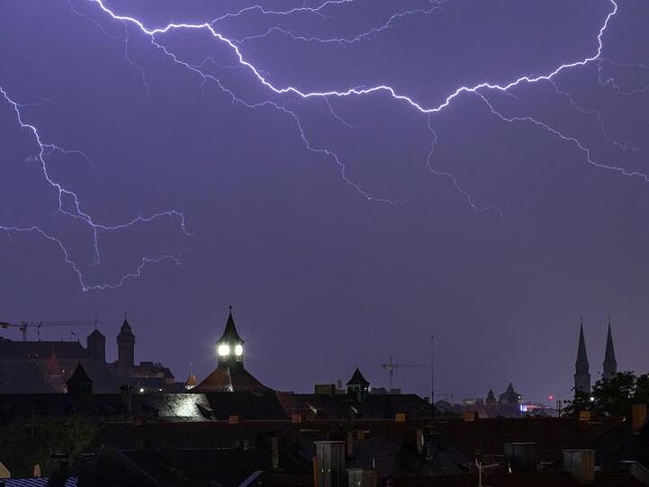 Blitze entladen sich während eines Gewitters am Himmel. Foto: Daniel Karmann/dpa/Archivbild
