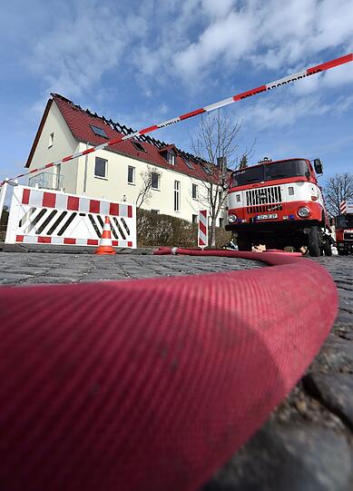 Einsatzkräfte von Feuerwehr und Polizei stehen vor der zukünftigen Unterkunft für Asylbewerber in Tröglitz.