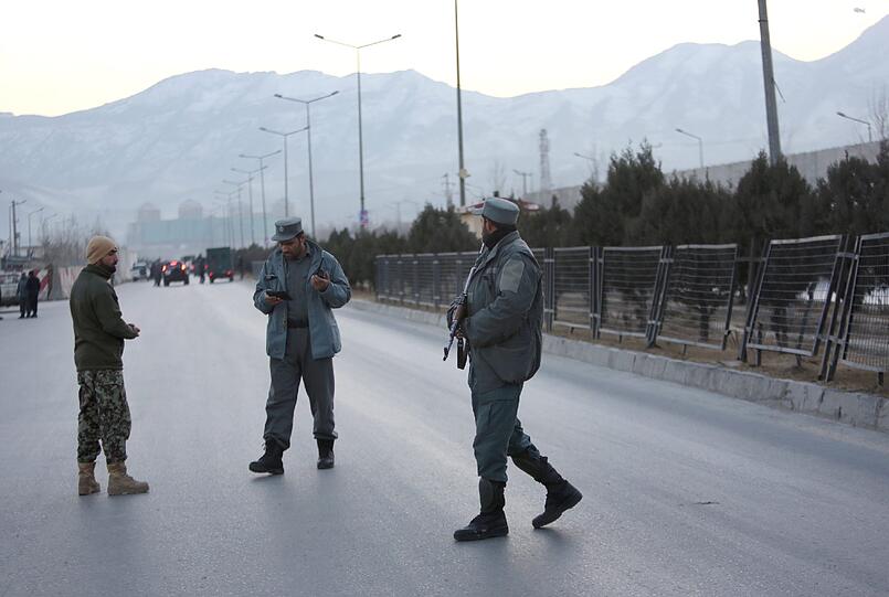 Mitglieder der afghanischen Sicherheitskräfte stehen am Dienstag nahe des Ortes zweier Explosionen in Kabul.