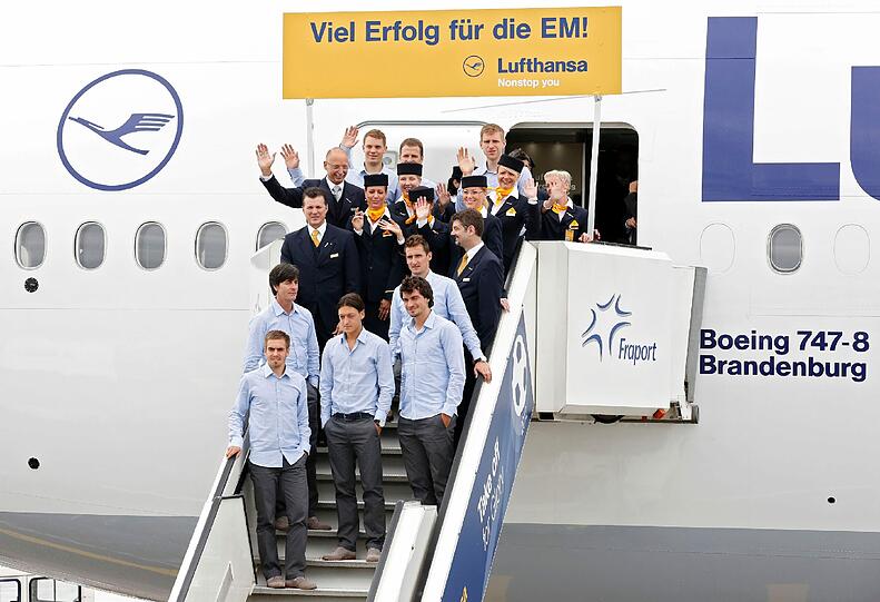 Jetzt sind sie auf dem Weg nach Polen: Die Nationalspieler um Bundestrainer Joachim Loew (2.v.l.) posieren mit Crewmitgliedern der Luftfahrtgesellschaft Lufthansa auf einer Gangway vor einer Maschine vom Typ Boeing 747-8