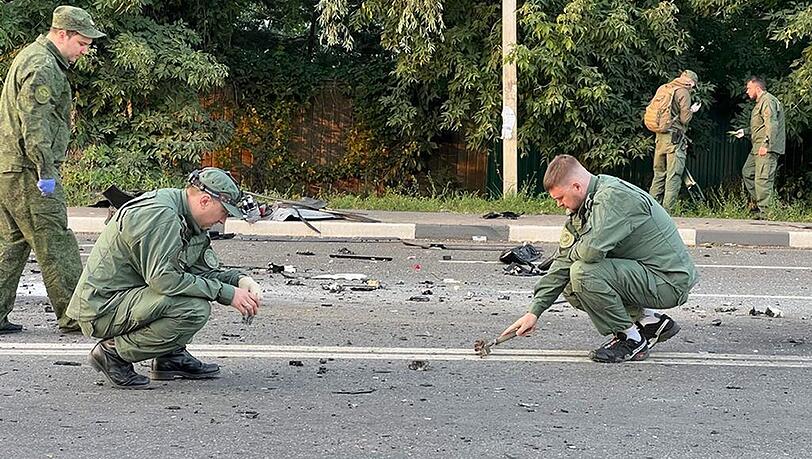 Ermittler am Ort der Explosion eines von Daria Dugina gefahrenen Autos außerhalb von Moskau.