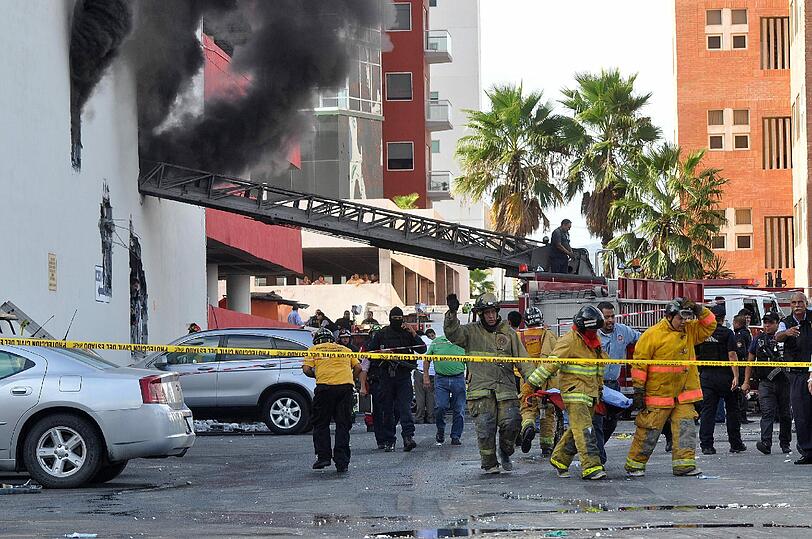Geordnetes Chaos: Während die Feuerwehr die Flammen bekämpft...
