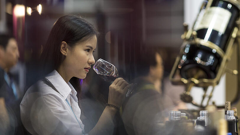 Eine Besucherin einer Weinmesse in Hongkong probiert einen Wein.