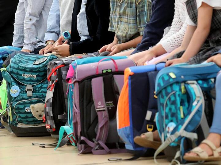 Kinder warten auf den Beginn der feierlichen Einschulung an einer Grundschule. Foto: Bernd Wüstneck/dpa/Symbolbild