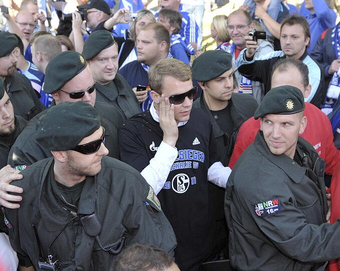 Au Backe! Polizisten schützen Manuel Neuer, nachdem der Torwart von einem Fan geohrfeigt worden war.