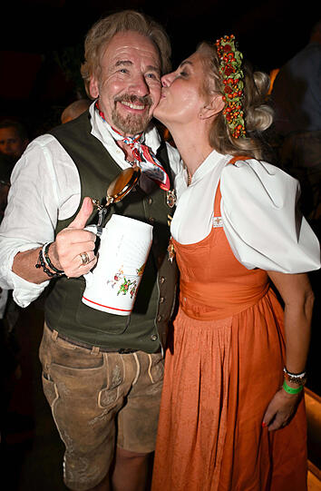 Thomas Gottschalk und Ehefrau Karina: Die beiden frisch verheirateten Turteltauben sind perfekt aufeinander abgestimmt. Karina hat sich für die supermodischen Puffärmel entschieden und das mit einem klassischen Dirndl kombiniert. Perfekt! Und Thomas gibt dem tollen Look natürlich sein gewisses Etwas mit dem abgestimmten Halstuch und einigen Ansteckern. Fesch sehen die beiden aus!