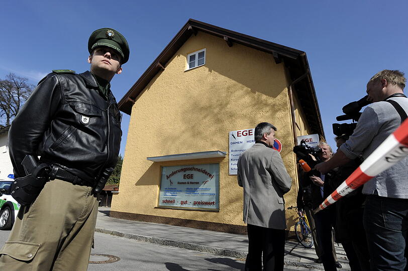 Polizisten, Kriminalpolizei und Journalisten vor dem Haus.