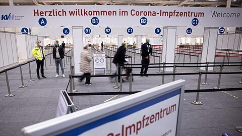 Zwei Senioren (M) sind im Eingangsbereich des Corona-Impfzentrums in den Hamburger Messehallen auf dem Weg zur Impfung.