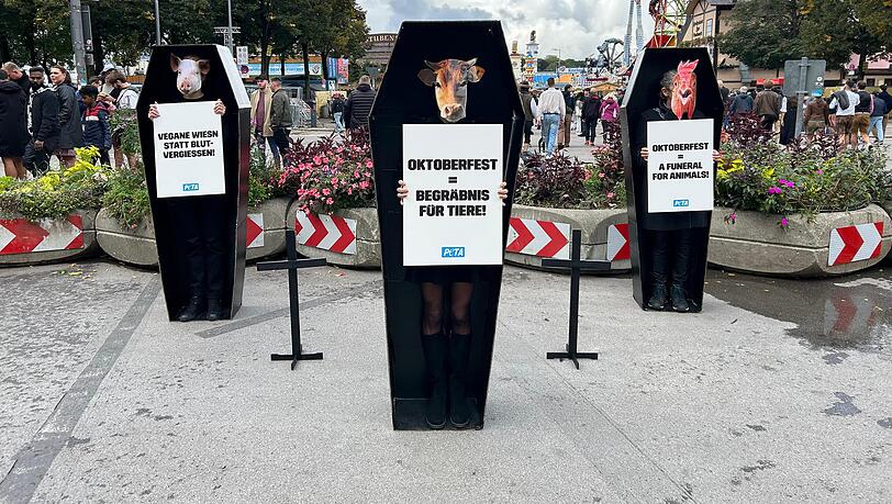Mitglieder von PETA demonstrieren vor dem Festgelände.