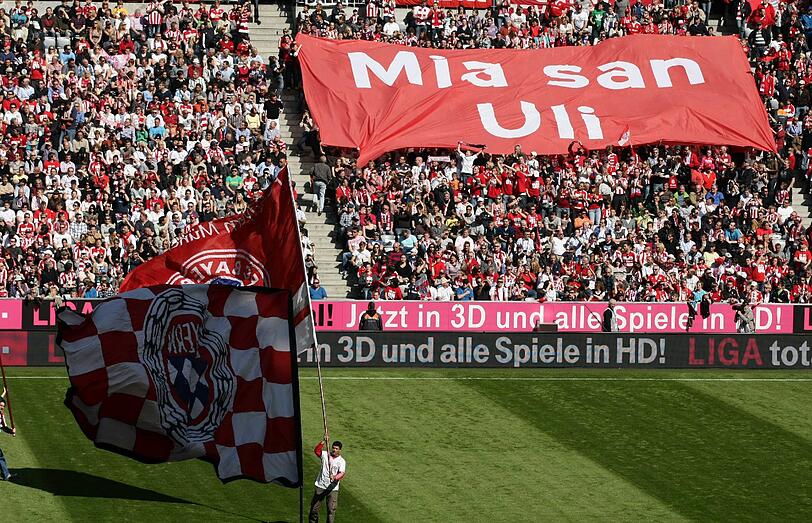 "Mia san Uli"-Schriftzüge auf T-Shirts und Plakaten in der Arena.