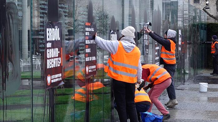 Klimaaktivisten der "Letzten Generation" beschmieren die gläserne Grundgesetz-Skulptur im Regierungsviertel und kleben Plakate darauf.