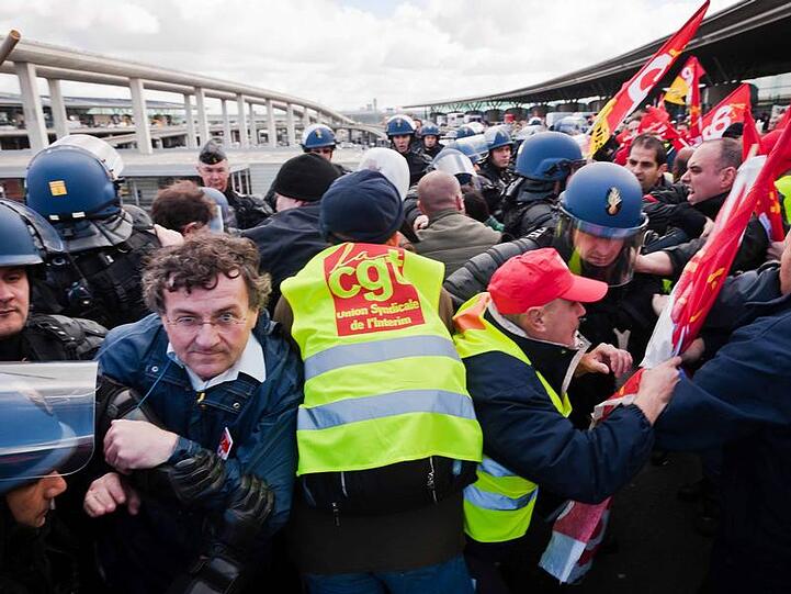 Demonstranten bei einer Rangelei mit Polizisten an einem Flughafen in Frankreich. (Archivbild)