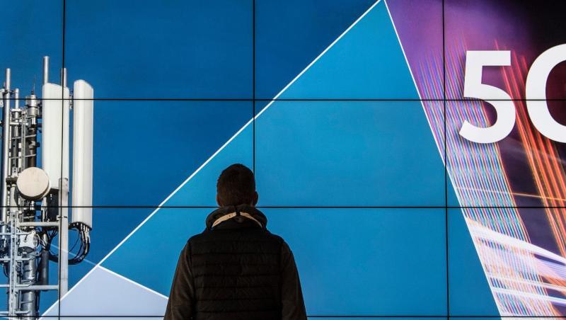 Ein Mann steht im Gebäude der Bundesnetzagentur vor einer Leinwand mit der Aufschrift "5G". Die Bundesnetzagentur versteigert 41 Frequenzblöcke an verschiedene Anbieter. Ein Mann steht im Gebäude der Bundesnetzagentur vor einer Leinwand mit der Aufschrift "5G". Die Bundesnetzagentur versteigert 41 Frequenzblöcke an verschiedene Anbieter.
