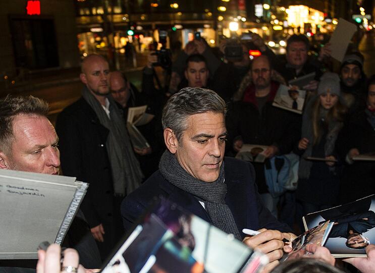 Der US-amerikanische Schauspieler George Clooney gibt am 08.02.2014 vor dem Restaurant Bocca di Bacco in Berlin Autogramme. Dort feierte er die Berlinale-Premiere des Films "The Monuments Men" mit geladenen Gästen.