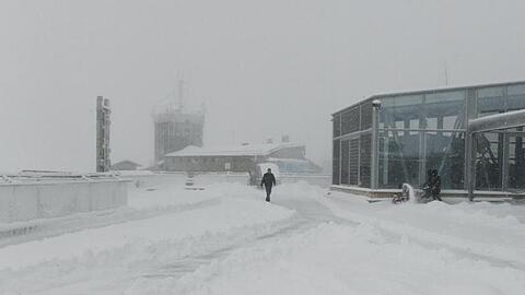 Ein Mann geht über die verschneite Dachterasse von der Zugspitze. Foto: Angelika Warmuth/dpa/Archivbild