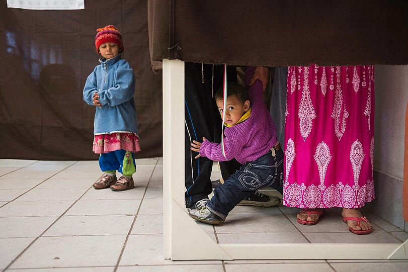 Anwohner Andrea Rostas (R) und ihr Partner, Janos Makula (verdeckt), stehen in einer Wahlkabine, mit ihren Kindern in Tiszavasvari, 200 km östlich von Budapest, während der Parlamentswahlen in Ungarn. Mehr als 8 Millionen Wahlberechtigten werden voraussichtlich zu den Urnen gehen, um 199 Abgeordnete statt der bisherigen 386 Abgeordneten in den ersten Einzeldurchgang der Parlamentswahlen seit 1990 zu wählen.