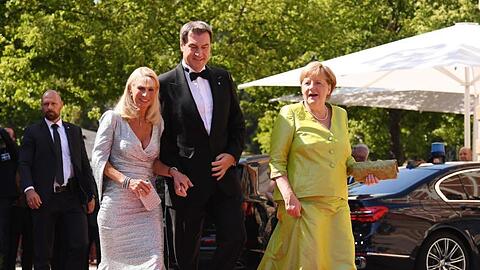 Bundeskanzlerin Merkel (CDU, r) zusammen mit dem Bayerischen Ministerpräsidenten Söder (CSU) und dessen Frau. Foto: Tobias Hase