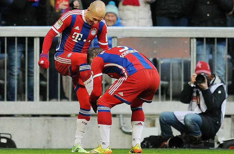 Arjen Robben bekommt von Bastian Schweinsteiger die Schuhe geputzt.