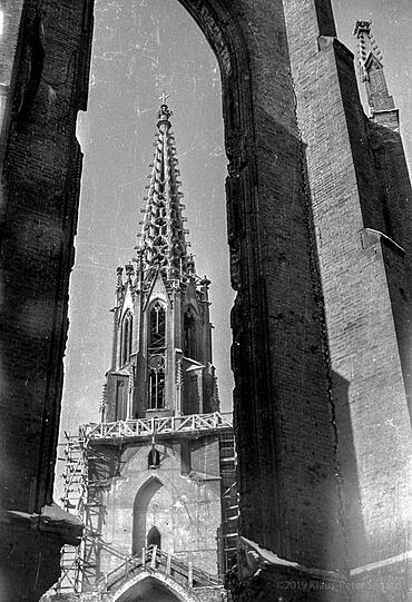 Blick durch die zerstörten Fenster der Mariahilfkirche auf den Turm. 1971 muss die Turmspitze aus Kalkstein abgetragen und 1981 durch einen neuen Betonguss ersetzt werden.