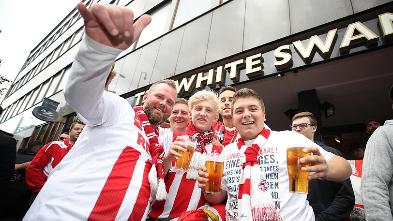 FC Köln-Fans feiern vor dem White Swan Pub in Mannschaftskleidung.