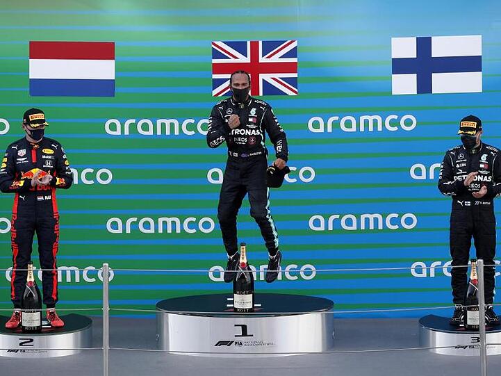 Der zweitplatzierte Max Verstappen (l-r), der Sieger Lewis Hamilton und der drittplatzierte Valtteri Bottas feiern auf dem Podium.