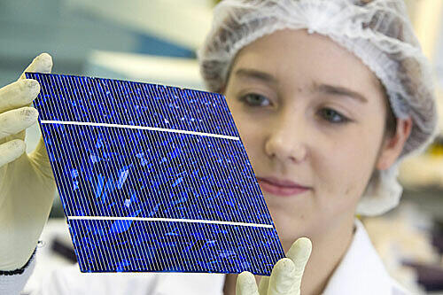 Ein Azubi kontrolliert bei Bosch eine Solarzelle.