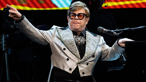 Der Sänger und Pianist Elton John sitzt in der Olympiahalle bei einem Konzert im Rahmen seiner "Farewell Yellow Brick Road Tour 2023" auf der Bühne.