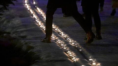 Kerzen in einer symbolischen Loipe erinnern an Laura Dahlmeier.