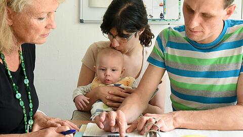 Eine Familie rechnet monatliche Unkosten aus. Worauf muss man bei seinen Finanzen achten?