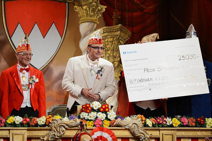 Sitzungspräsident Bernd Händel auf der Prunksitzung des Fränkischen Fastnachtsverbandes einen Schweigegeldscheck in Höhe von 25.000 Euro für Peer Steinbrück.