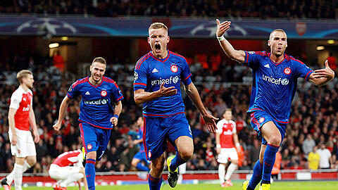 Jubel bei den Siegern von Olympiakos Piräus, Frust beim Verlierer FC Arsenal (hinten Per Mertesacker).