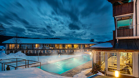 Winterzauber im Lindenwirt: der beheizte Infinity-Pool mit Blick auf die verschneite Landschaft des Bayerischen Waldes.