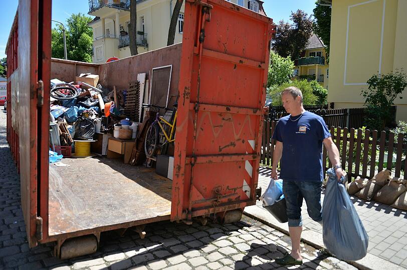 Ein Mann trägt nach dem Hochwasser der Weißen Elster in Gera Untermhaus vom Hochwasser zerstörte Sachen in einen Container. Nach mehreren Tagen ist der Katastrophenalarm in Gera am Mittwochmorgen aufgehoben worden.